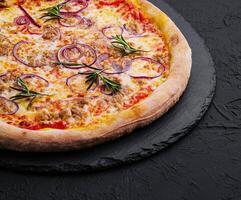 Pizza with tuna and red onion on stone cutting board photo
