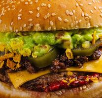 veggie burger with guacamole and pickles on toasted bun photo