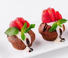 Cupcakes with strawberries on white plate photo