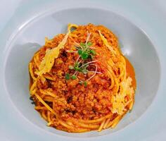 Spaghetti bolognese with parmesan cheese and tomatoes photo