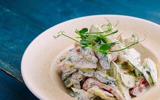Salad with fresh vegetables and cream sause on plate photo