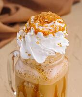 Caramel iced latte with whipped cream and syrup photo