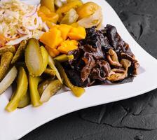 Marinated salty vegetables in the plate photo