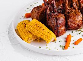rack of lamb with corn and carrots photo