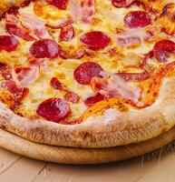 pepperoni Pizza con jamón en madera foto
