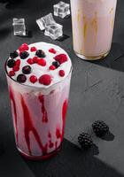 Delicious milkshakes on black stone with ice cubes photo