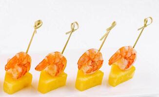 Canapes with shrimp and pineapple on plate photo