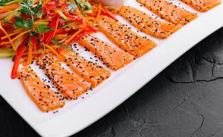 Salmon Slices with Carrot and Pepper Salad and Soy Sauce - Asian Cuisine photo