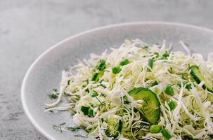 Spring vegan salad with cabbage, cucumber, green onion and peas photo