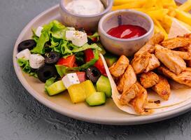 fried chicken breast meat and Greek salad photo