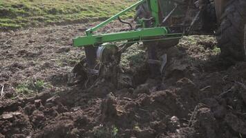 une petit tracteur dans une montagneux zone. une tracteur charrues une champ avec une charrue sur une petit cultiver. magnifique 4k vidéo. charrue fermer. video