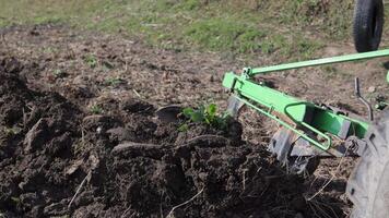 ein klein Traktor im ein bergig Bereich. ein Traktor pflüge ein Feld mit ein Pflug auf ein klein Bauernhof. schön 4k Video. Pflug Nahansicht. video