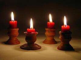 Four Red Candles Burning In Wooden Holders photo