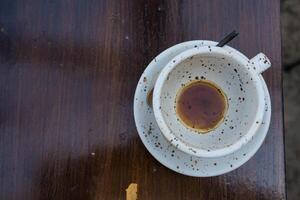 Empty coffee cups with stains left in the cups on the wooden table in the cafe. photo