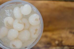 Longan juice in a clear plastic glass photo