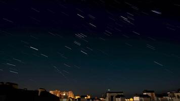 tid upphöra av stjärna spår i de natt himmel över de stad. 4k video