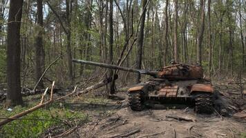 förstörd och bränt ut tank av de ryska armén som en resultat av de slåss med ukrainska trupper i de skog nära Kiev, ukraina. ryska aggression i ukraina. video