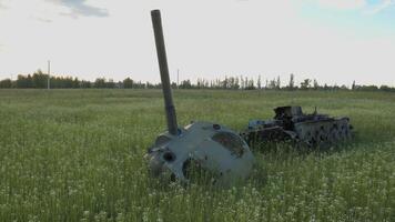 The remains of a burnt tank in a field near Kyiv. Grass and spring flowers grow around the remnants of the tank. The concept of starting a new life after the end of the war. video