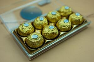 Bangkok, Thailand - February 29, 2024 Ferrero Rocher candy in plastic container. Candy in branded packaging. photo