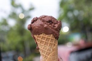 Chocolate ice cream cone on hand. photo