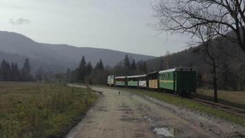 Antenne Aussicht von ein Zug Reisen auf das Eisenbahn. Flug von ein Drohne hinter ein Zug Reisen auf ein eng Spur Eisenbahn. video