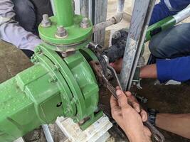Worker maintenance and rectify motor service water pump on power plant project. The photo is suitable to use for industry background, power plant poster and electricity content media.
