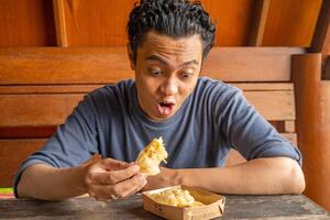 hombre expresión contento sonrisa sorprendido cuando comer el plátano papas fritas el foto es adecuado a utilizar para sano cuidado, hombre expresión anuncio y diario actividad contenido medios de comunicación.