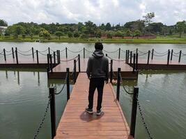 Man stand in front of the way lake on down town. The photo is suitable to use for adventure content media, nature poster and forest background.