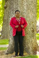 Older Black Woman Standing Outdoor Red Jacket photo