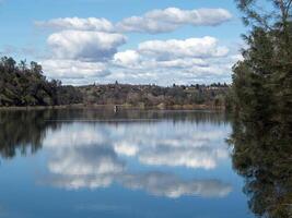 white clouds and blue sky reflected in lake photo