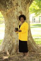 Smiling African American woman holding Bible outdoors photo