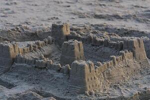 Sand Castle With Turrets And Walls On Beach photo