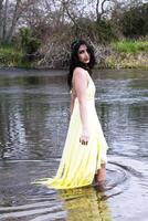joven este indio mujer en pie en río foto