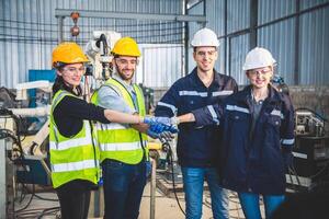 Engineers team mechanic making pile of hands in steel factory workshop. Industry robot programming software for automated manufacturing technology photo