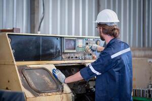 Portrait of Heavy industry workers working on the metal fabrication process by operating a lathe at a machine for steel structure industry. photo