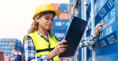 Women Engineer wears PPE checking container storage with cargo container background at sunset. Logistics global import or export shipping industrial concept. photo