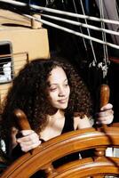 Mixed Heritage Woman At Wheel Of Tall Ship photo