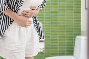 Constipation and diarrhea in bathroom. Hurt woman touch belly  stomach ache painful. colon inflammation problem, toxic food, abdominal pain, abdomen, constipated in toilet, stomachache, Hygiene photo