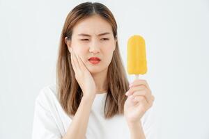 Asian woman feel sensitive teeth after eating ice cream, female suffer tooth, decay problems, dental care, tooth extraction, decay problem, bad breath, Gingival Recession, Oral Hygiene instruction photo