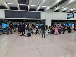 Banjarbaru, Indonesia - January 29th 2024 the atmosphere of people walking at the airport who want to leave or go home and using trolleys waiting for luggage photo