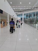 Banjarbaru, Indonesia - January 29th 2024 the atmosphere of people walking at the airport who want to leave or go home and using trolleys waiting for luggage photo