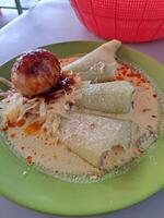 Vegetable lontong with coconut milk sauce with salted egg side dish photo