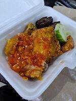 ayam penyet pollo es frito pollo rociado con muy picante chile salsa, esta plato se origina desde Indonesia foto