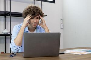 Caucasian man freelancer is having serious error problem with program while working at home having headache and frustration about online task for accountant, auditor, programer and broker occupation photo