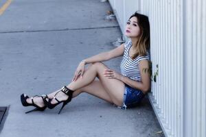 Asian American Woman Sitting In Jean Shorts And Top photo