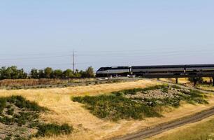 Davis, CA, 2015 - Passenger Train Pan Blur Against Blue Sky photo