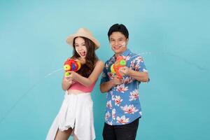 Happy Asian people use water guns to play Songkran in Thailand. photo