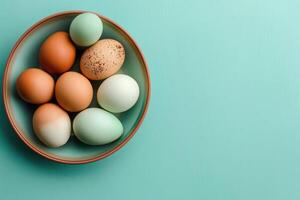 AI generated Top view of painted Easter Eggs in bowl on light blue pastel background. Holiday chicken food on banner with Copy space. Festive blank with empty place for text photo