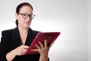 Mature business woman with glasses holding a digital tablet photo