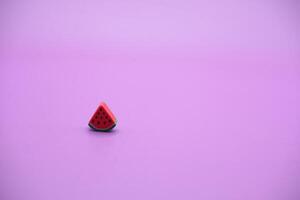 Mini watermelon toy isolated on purple background. purple background with watermelon toys. photo